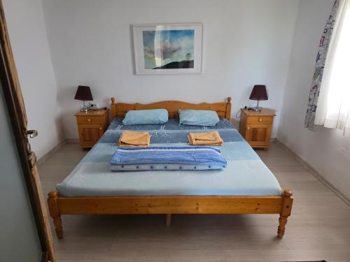 a bedroom with a bed with blue sheets and two tables at Sinemoria apartment in Sinemorets