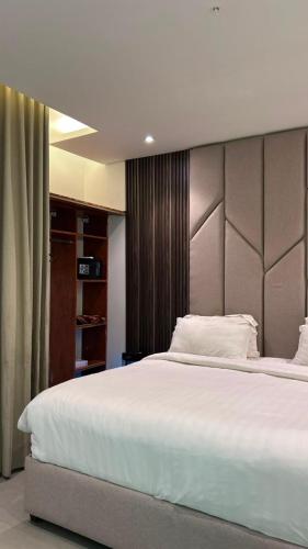 a bedroom with a large white bed with a headboard at Rose Beach 7 درة العروس in Jeddah
