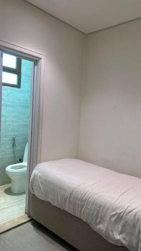a bedroom with a bed and a bathroom with a toilet at Rose Beach 7 درة العروس in Jeddah