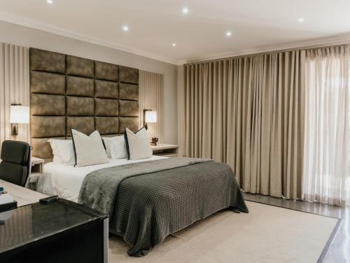 a bedroom with a large bed and a desk at Decollage Estate in Polokwane