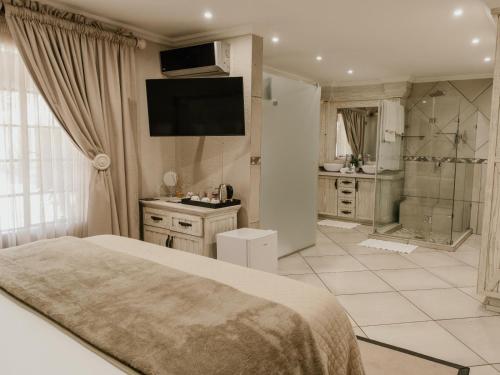 a bedroom with a bed and a bathroom with a shower at Decollage Estate in Polokwane