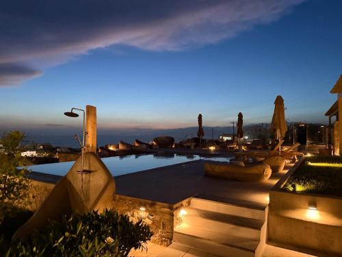 a view of a pool at night with lights at Ostria View Resort in Mikonos