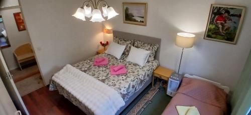 a small bedroom with a bed with pink cards on it at Saimaa Parkview Luxury Suite in Savonlinna