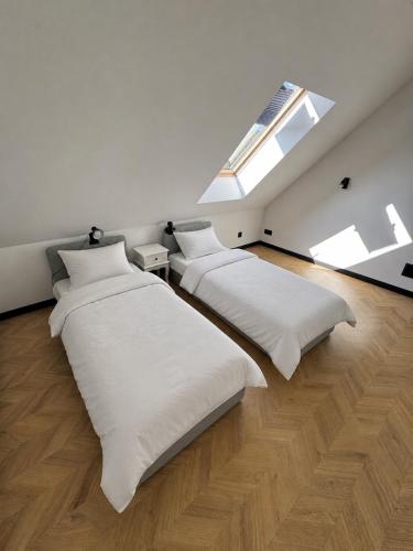 two beds in a room with two windows at Dom-na Mazury! in Mrągowo