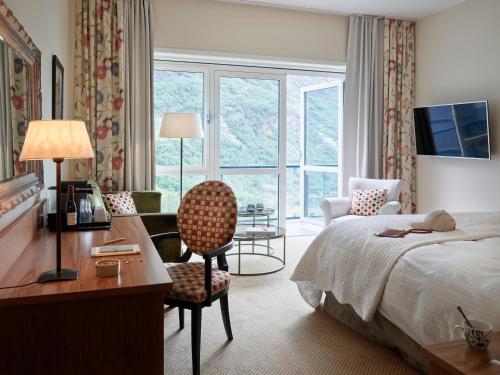 a hotel room with a bed and a desk and a chair at Hotel Union Geiranger Resort & Spa in Geiranger