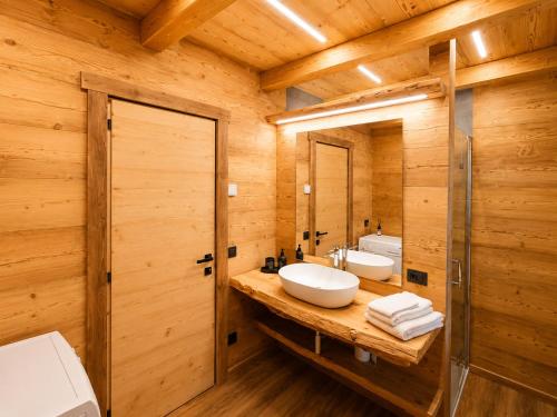 a bathroom with a sink and a mirror at SkyWood Chalet, Panoramic Mountain and Lake Views in Mello