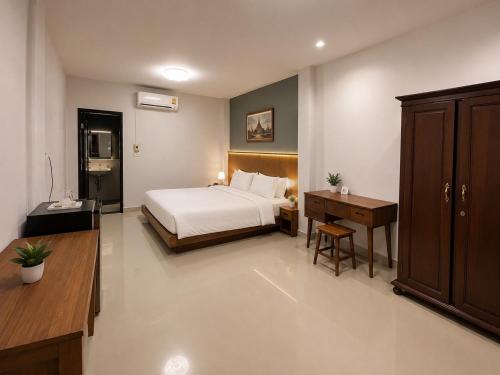 a bedroom with a bed and a desk and a bed sidx sidx sidx at Na Sukhothai Hotel in Sukhothai