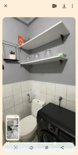 a bathroom with a white toilet and a black sink at Kawalerka in Kwidzyn