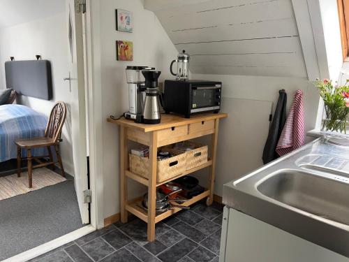 a small kitchen with a sink and a microwave at Friisenborg in Jelling