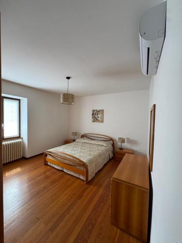 a bedroom with a bed and a wooden floor at La casa di Ernesto in Carlazzo