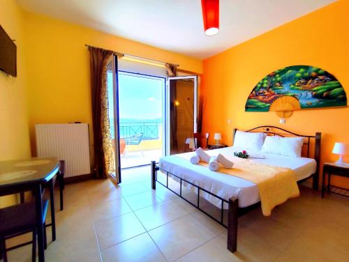 a bedroom with a bed and a large window at Villa Christine - Maisonettes with fireplace in Aliveri