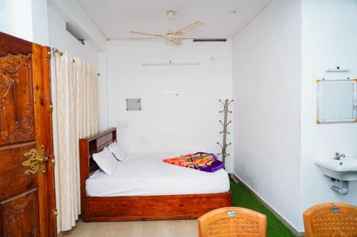 a small bedroom with a bed and a sink at River side in Vagamon