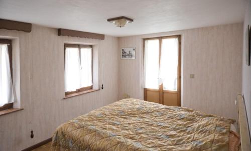 a bedroom with a bed in a room with windows at Dolomiti Bellunesi in Belluno