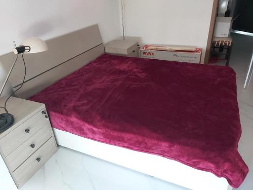 a bed with a purple blanket on top of it at Apartment Miki in Bar