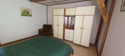 a bedroom with white cabinets and a green bed at Summers Breeze in Nantheuil