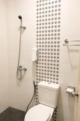 a bathroom with a toilet and a shower at Marina Jampea Hotel in Makassar