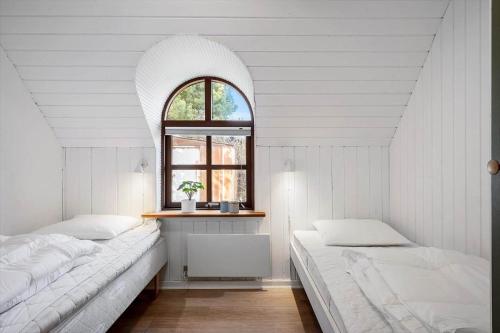 a white room with two beds and a window at 068-Ringkobing-Hvidbjergvej-4 in Søndervig