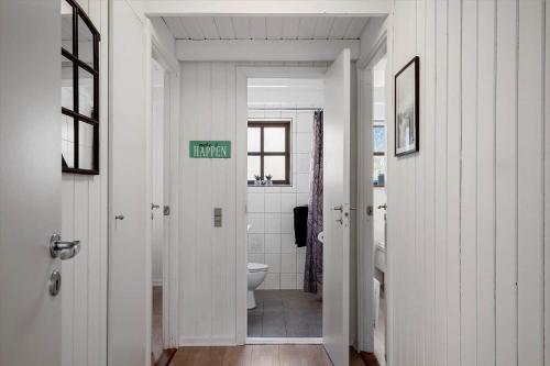 a white bathroom with a toilet and a sink at 068-Ringkobing-Hvidbjergvej-4 in Søndervig