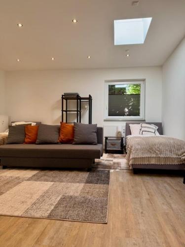 a living room with a couch and a bed at Bungalow Benther Berg, Contactless Check-in, Vollsaniert und Renoviert 2025 in Ronnenberg