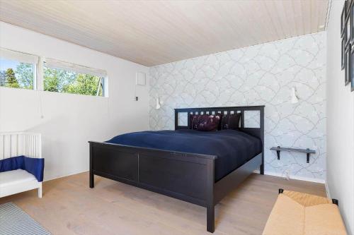 a bedroom with a blue bed in a white room at 1606-Liseleje-Lisevaenget-18 in Liseleje