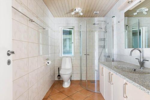 a bathroom with a toilet and a shower and a sink at 1606-Liseleje-Lisevaenget-18 in Liseleje
