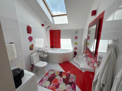 a white bathroom with a tub and a sink and a toilet at Rožu romantika in Cēsis