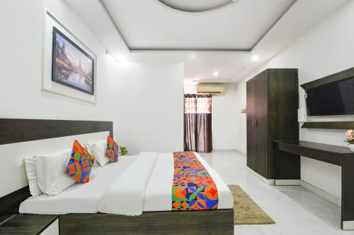 a bedroom with a bed and a tv at FabHotel Rajvanshi Palace in Gumgaon