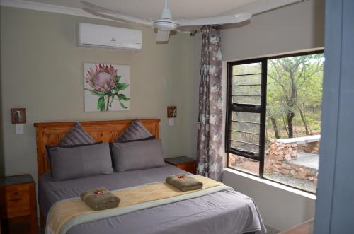 a bedroom with a bed with two stuffed animals on it at Sonador Bush House, 4bedr, 3bathr in Marloth Park in Marloth Park