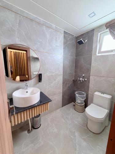 a bathroom with a sink and a toilet and a mirror at 4 Seasons Residency in Katra