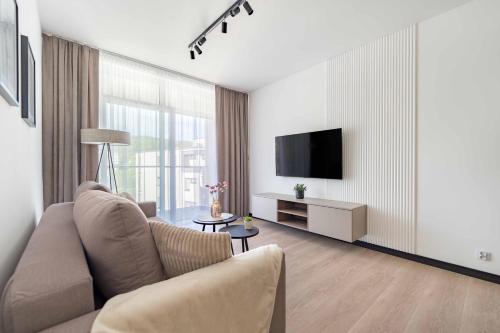 a living room with a couch and a tv at Apartament Panorama Pod Dębowcem in Bielsko-Biała