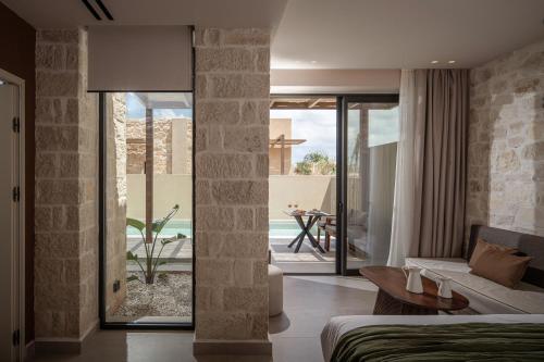 ein Schlafzimmer mit Bett und ein Wohnzimmer in der Unterkunft Socrates Hotel & Villas Malia Beach in Malia