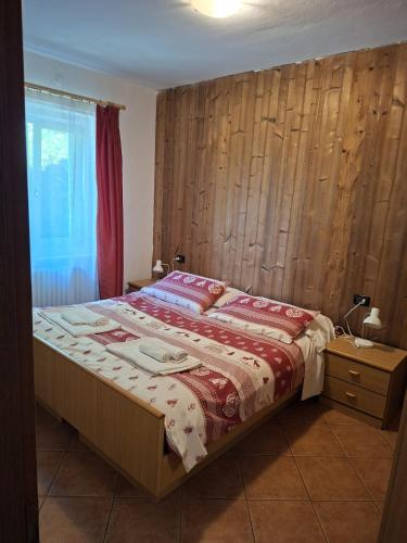 a bedroom with a bed with a wooden wall at Roda de Vael in Moena