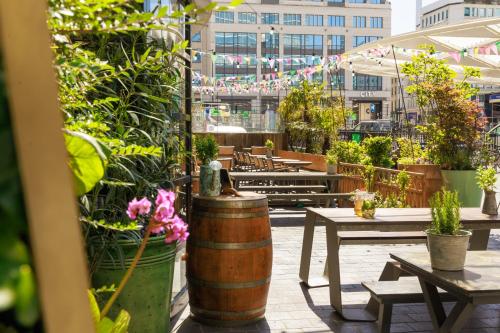 a patio with tables and chairs and potted plants at Hotel Indigo Brussels - City by IHG in Brussels