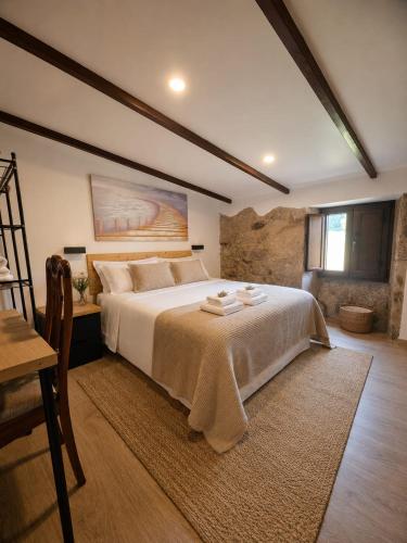 a bedroom with a large bed and a table at O Rincón de Esther in Vedra