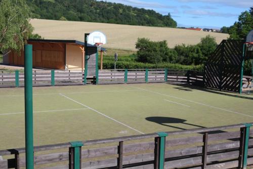 a tennis court with a basketball hoop on it at Eco-Bivouac in La Tagnière