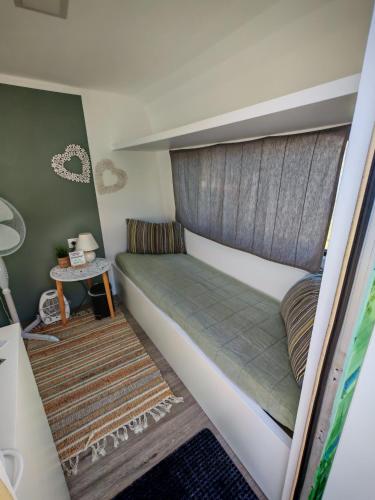 a small room with a bed and a table at Glamping Langus in Topolšica