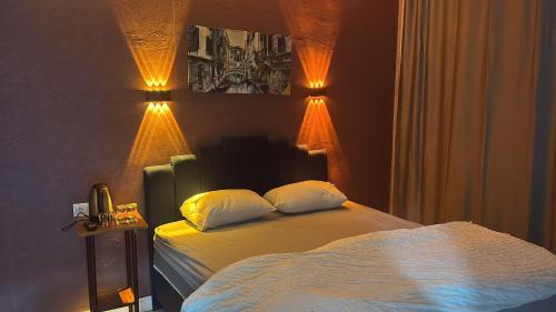 a bedroom with a bed with two pillows and lights at Çankaya Otel in Altındağ