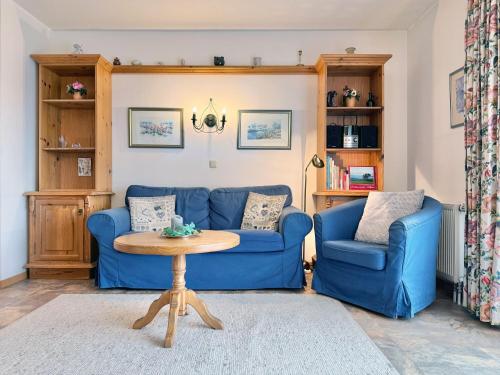 a living room with a blue couch and a table at Sonnenhof Seeg 01 in Seeg