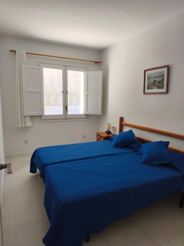 a bedroom with a blue bed and a window at Apartamento Blanes Vela Port in Blanes