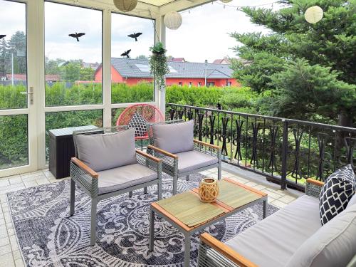 a screened porch with chairs and tables and windows at Wildbiene in Lübbenau