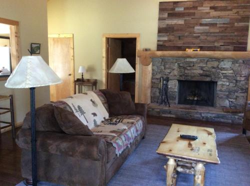 a living room with a couch and a fireplace at Dancing Bear Lodge in Townsend