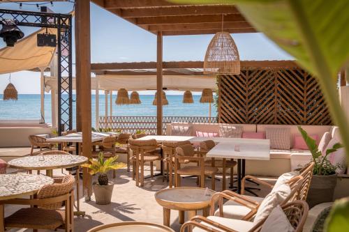 a restaurant with tables and chairs and a view of the ocean at CP Seafront Suites in Laganas