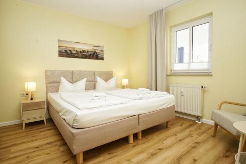 a bedroom with a large bed and a window at Haus Rügen Ferienwohnung 08 mit Sauna- und Schwimmbadnutzung im AHOI Sellin in Göhren