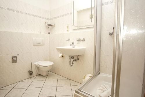a bathroom with a sink and a toilet and a shower at Haus Rügen Ferienwohnung 08 mit Sauna- und Schwimmbadnutzung im AHOI Sellin in Göhren