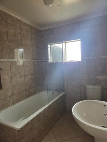 a bathroom with a bath tub and a sink at Mountain Shadows Hotel in Barkly East