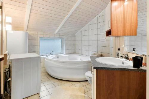 a bathroom with a tub and a toilet and a sink at M12018-Vaeggerlose-Baeverstien-11 in Bøtø By