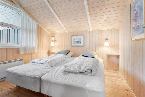a bedroom with two beds with white sheets and a window at M12018-Vaeggerlose-Baeverstien-11 in Bøtø By