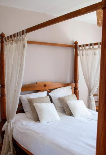 a bedroom with a wooden bed with white pillows at Maison avec sauna en Presqu'île de Crozon pour 6 personnes in Crozon