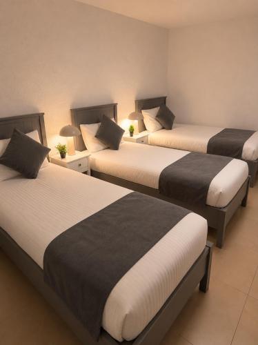 three beds in a room with two beds sidx sidx sidx at NEU! Fly & Stay Residence Frankfurt Airport Kelsterbach in Kelsterbach