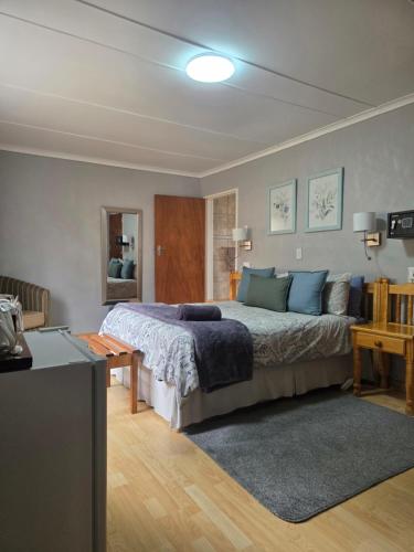 a bedroom with a large bed with blue pillows at Mountain Shadows Hotel in Barkly East
